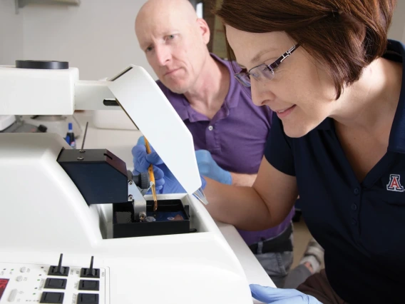 two people look at equipment in a lab
