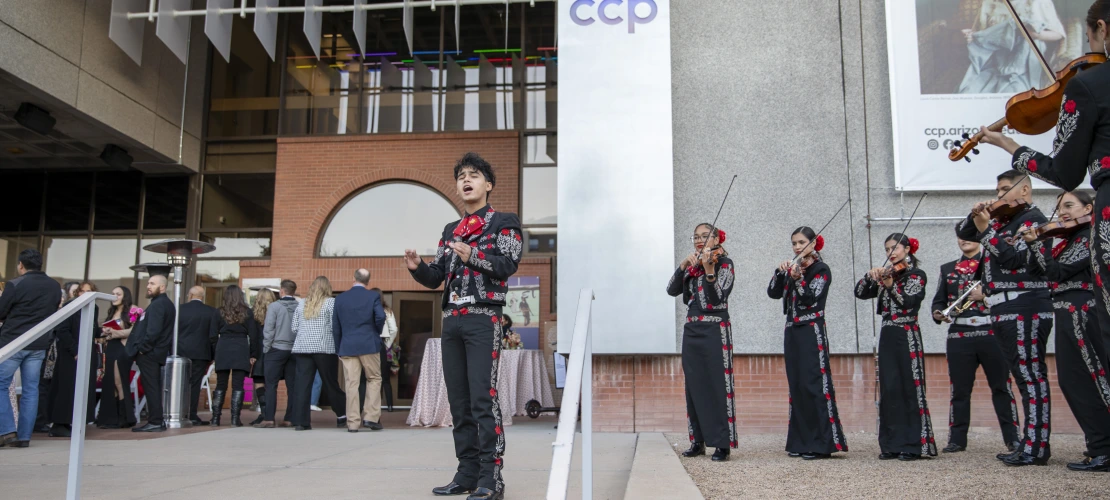 A mariachi band plays to a crowd in front of the Center for Creative Photography.