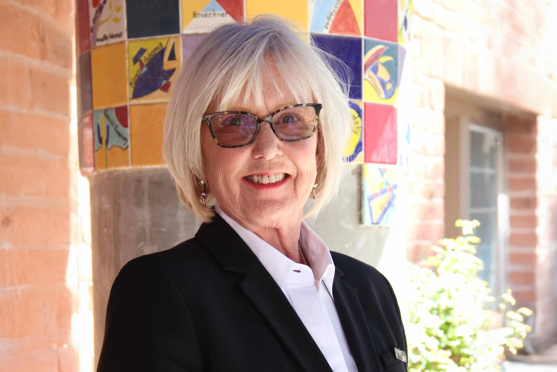 portrait of Claudia Nelson wearing white shirt and black blazer
