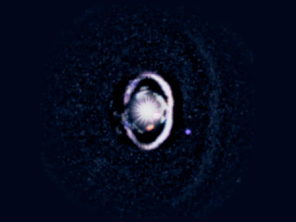 The star, WISPIT 2, appears a bright spot in the center, surrounded by a white, bright ring of dust. Two small dots indicate the growing protoplanets in the system. 